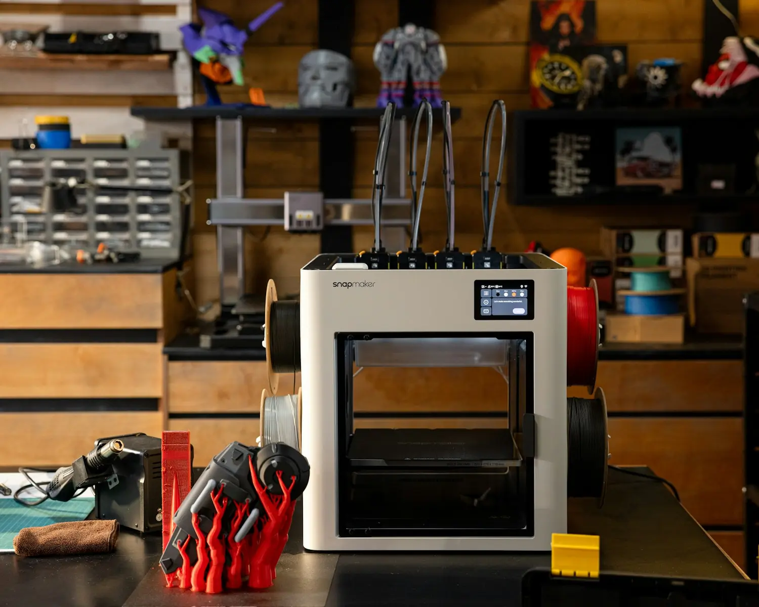 Oficina da Inovari com impressoras 3D, ferramentas e peças impressas.